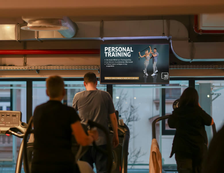 Cardio-Bereich mit Werbe- und TV-Screen an der Wand